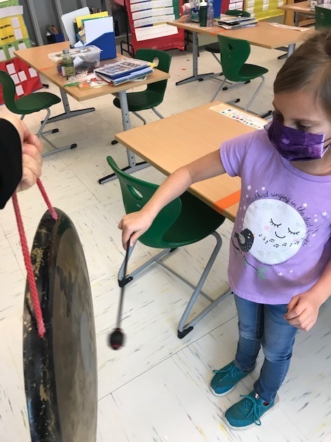 A student hitting a gong