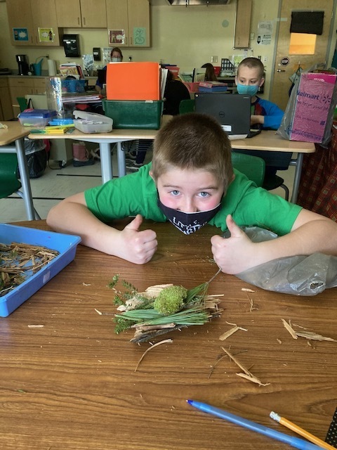 Student giving thumbs up to his bird nest